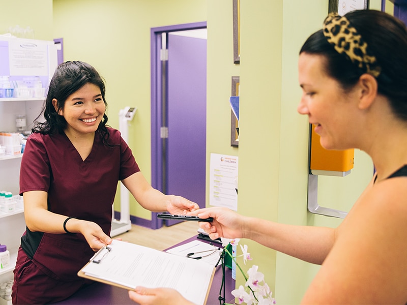 Nurse practitioner handing patient a form