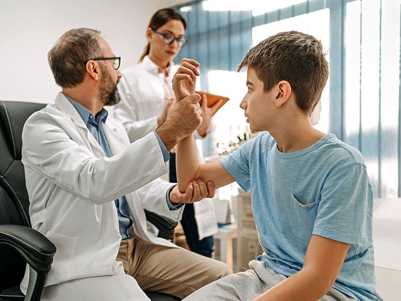 Physician at Urgent Care for Children checking a child's arm