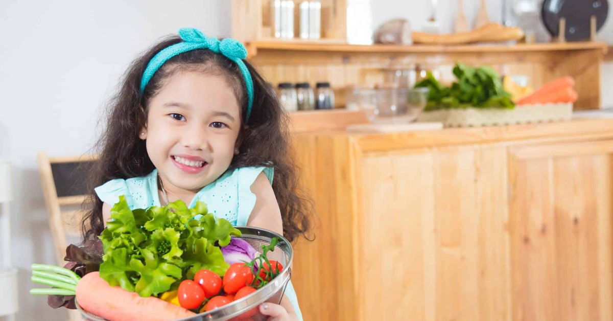 child holding vegetables after visit with Urgent Care for Children